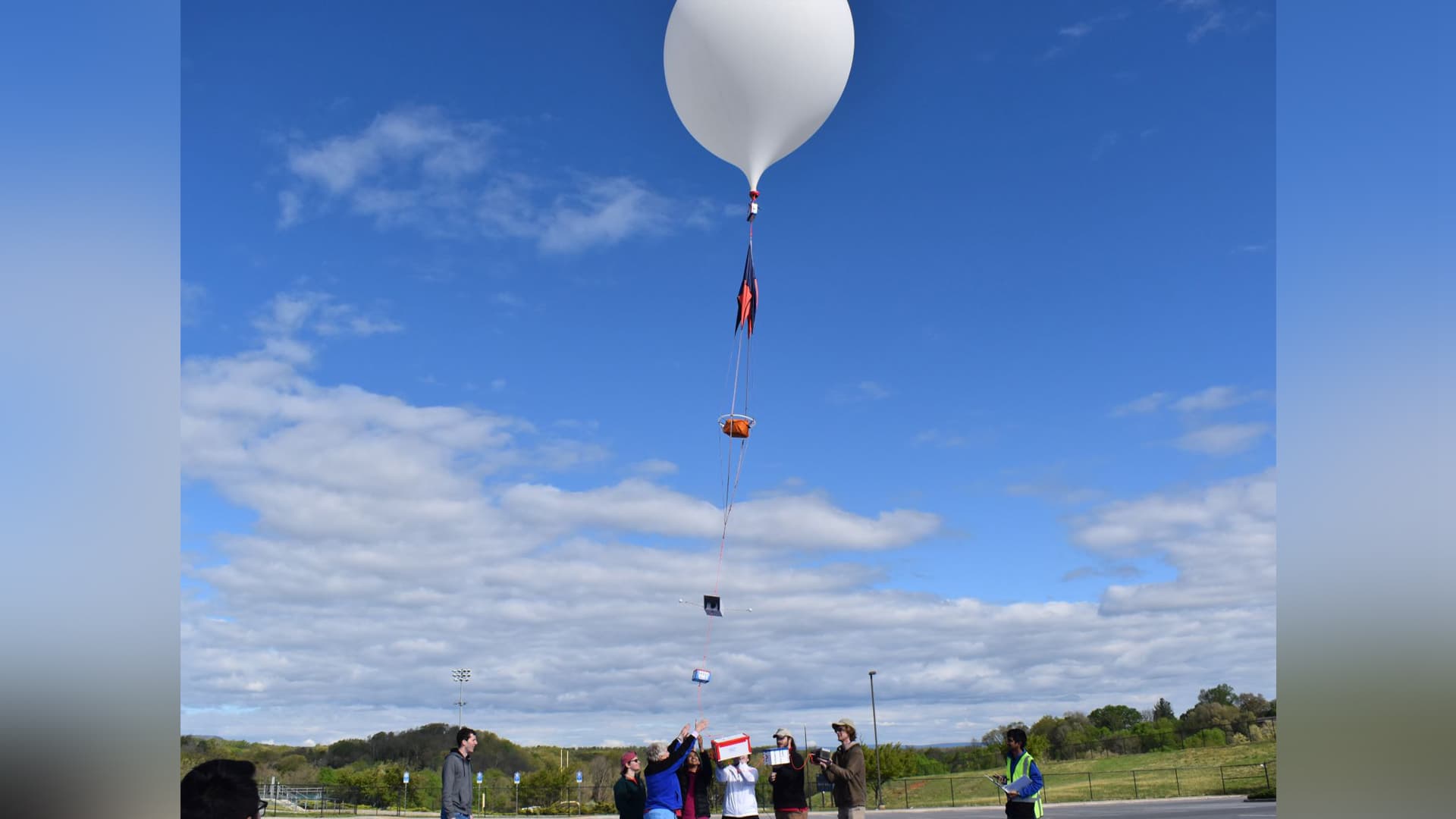 students let go of a large white balloon