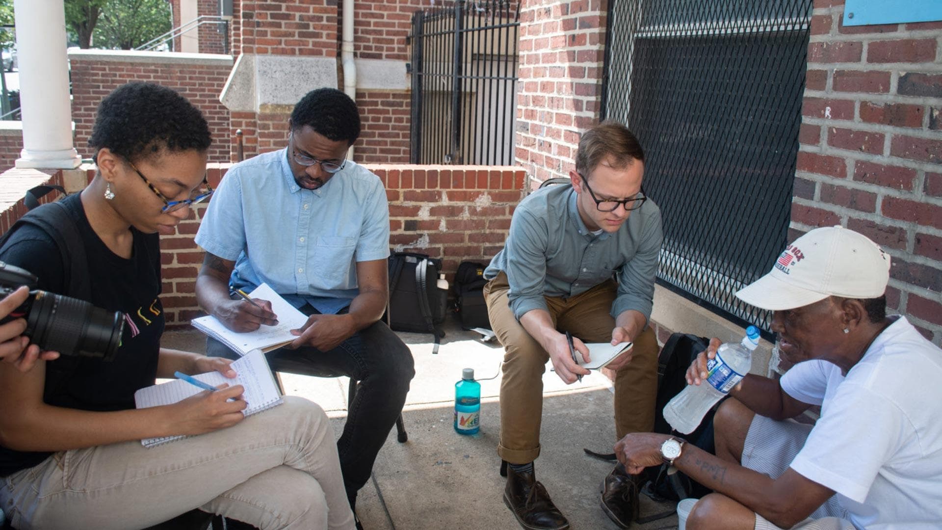 Student journalists interview source on porch