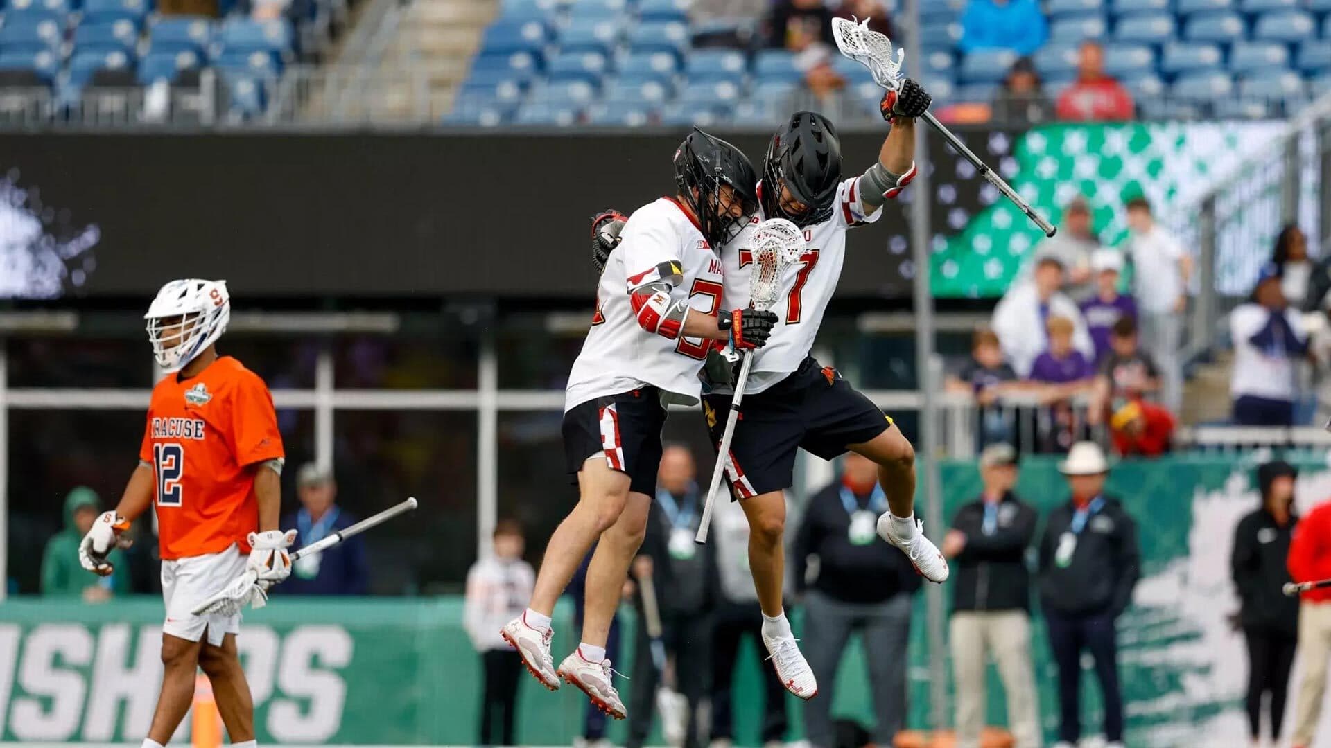 two Maryland lacrosse players jump in celebration