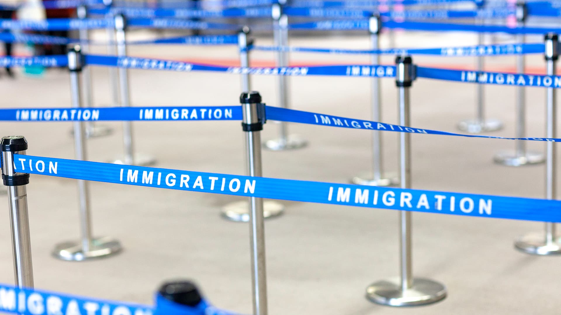 Line barriers with "immigration" written on them