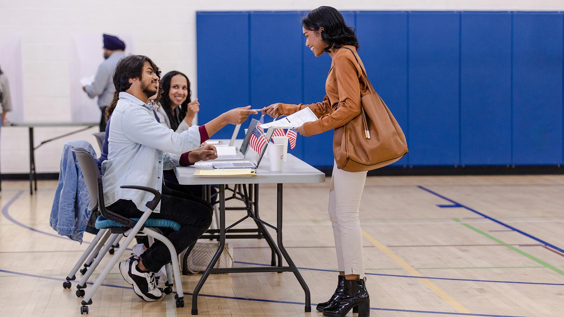 young poll worker helps voter