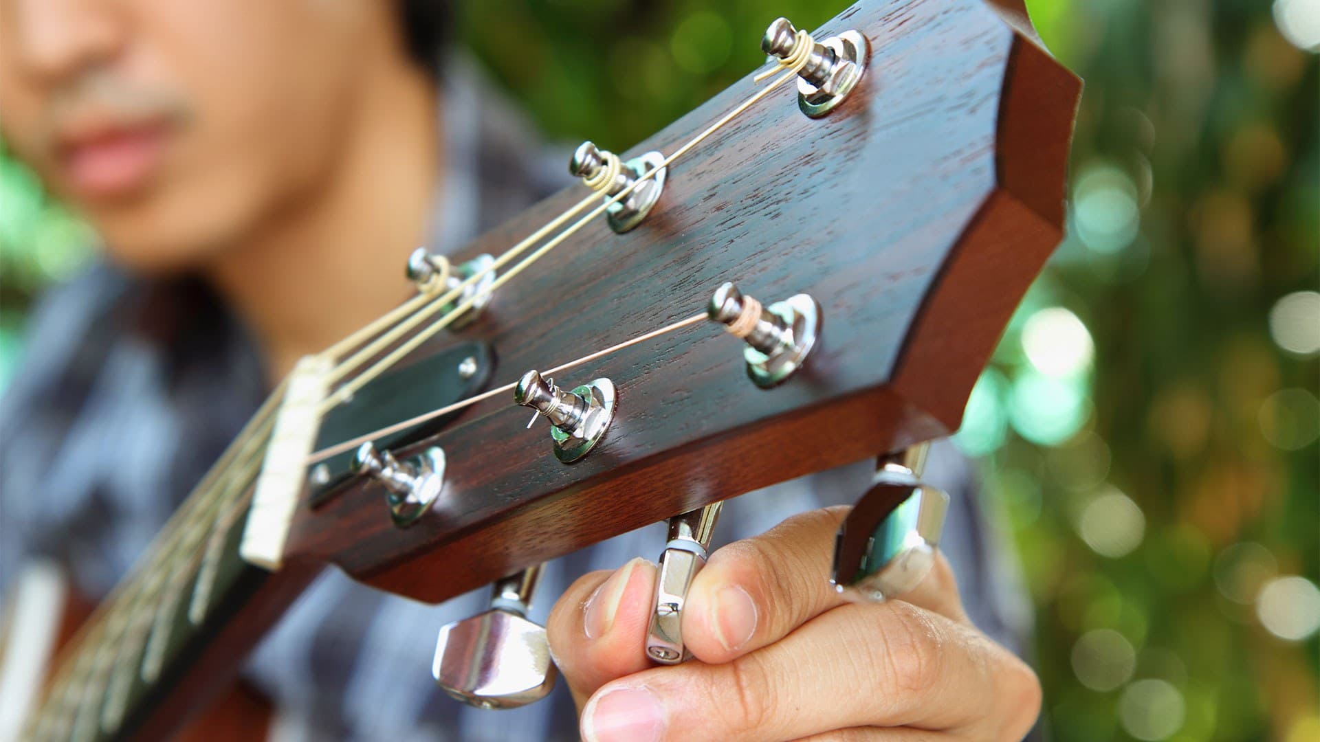 closeup of person tuning guitar