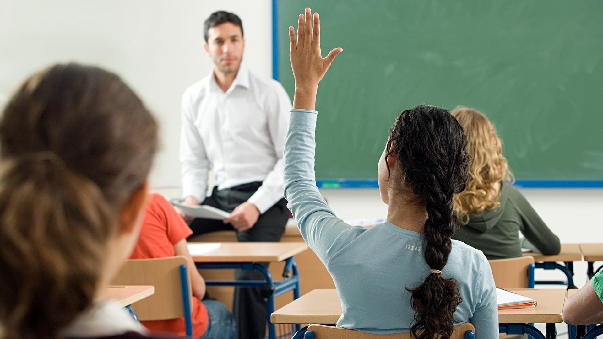 Student raises hand in classroom
