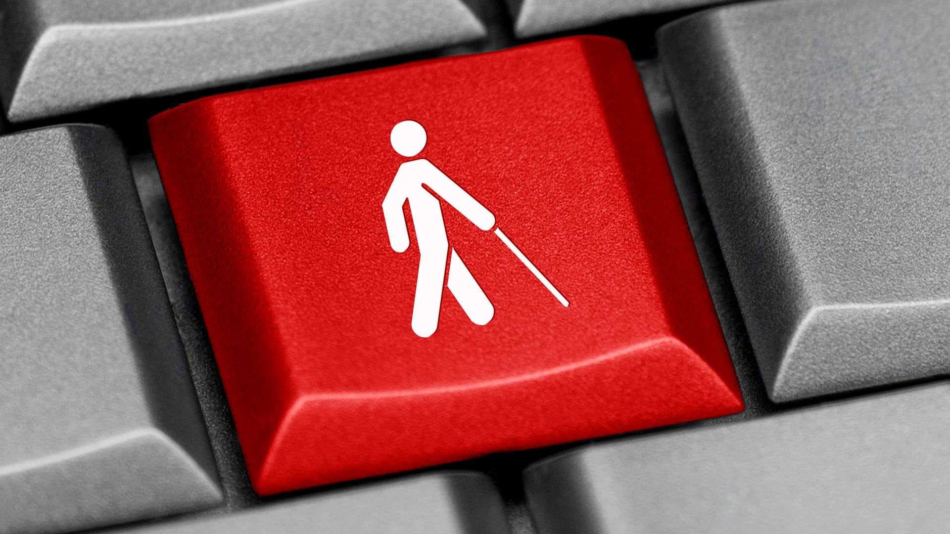 Closeup of a red keyboard key with a white accessibility icon showing a person using a cane