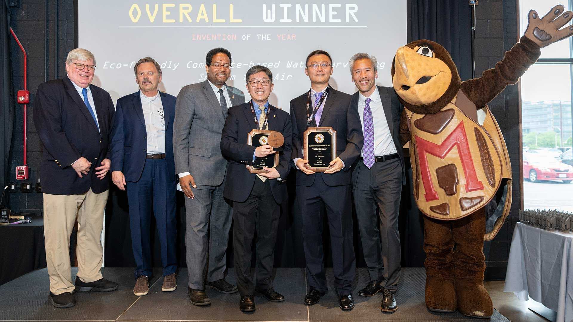 Invention of the Year winners hold awards on stage with Testudo and UMD leaders