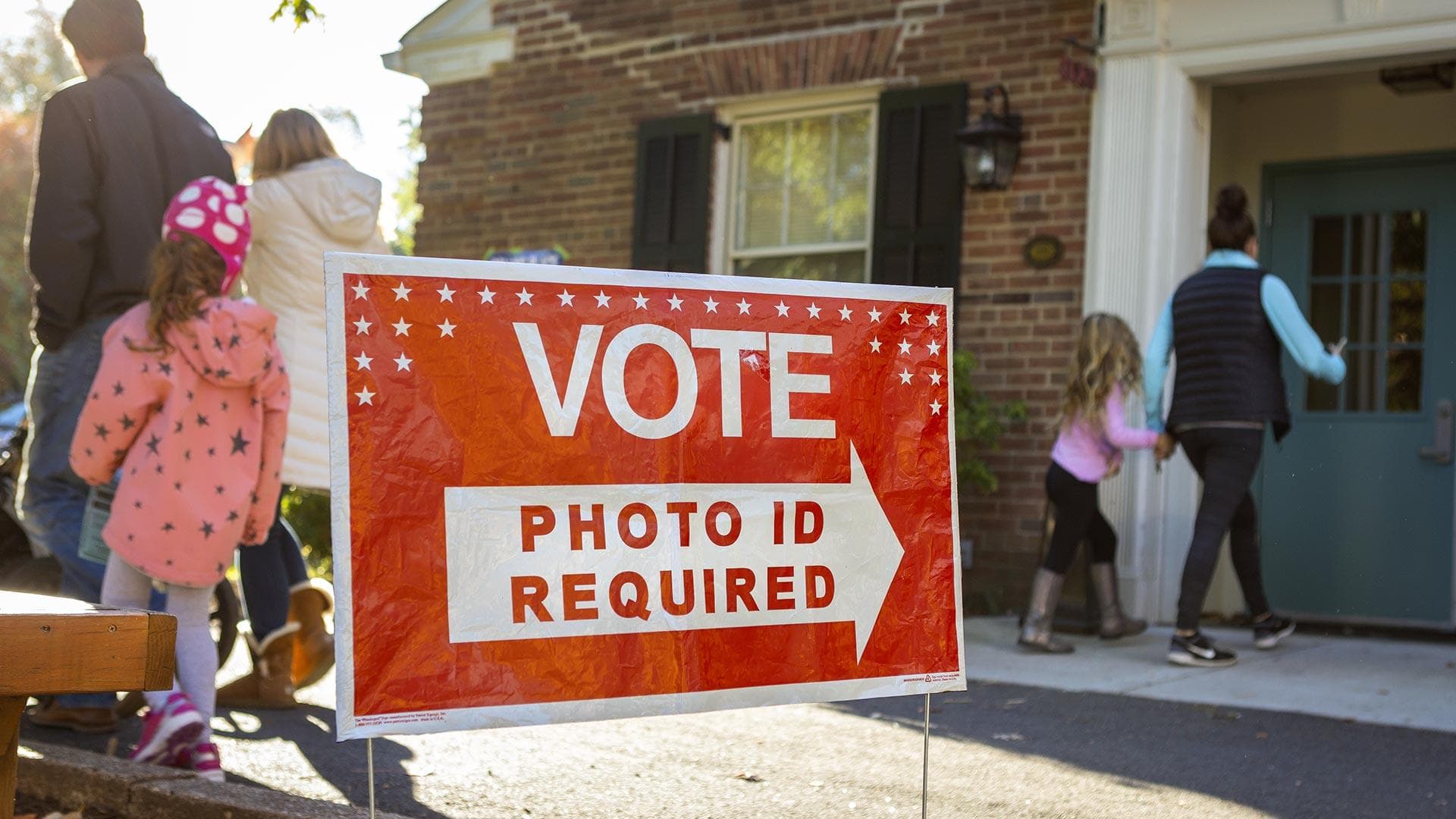 red lawn sign that reads, "VOTE: PHOTO ID REQUIRED"