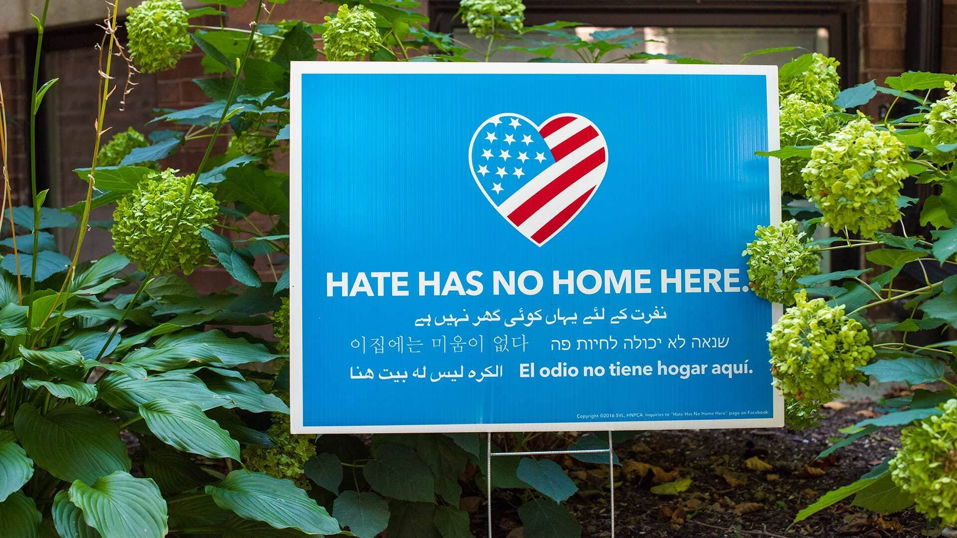 Lawn sign that reads, "Hate has no home here" in different languages