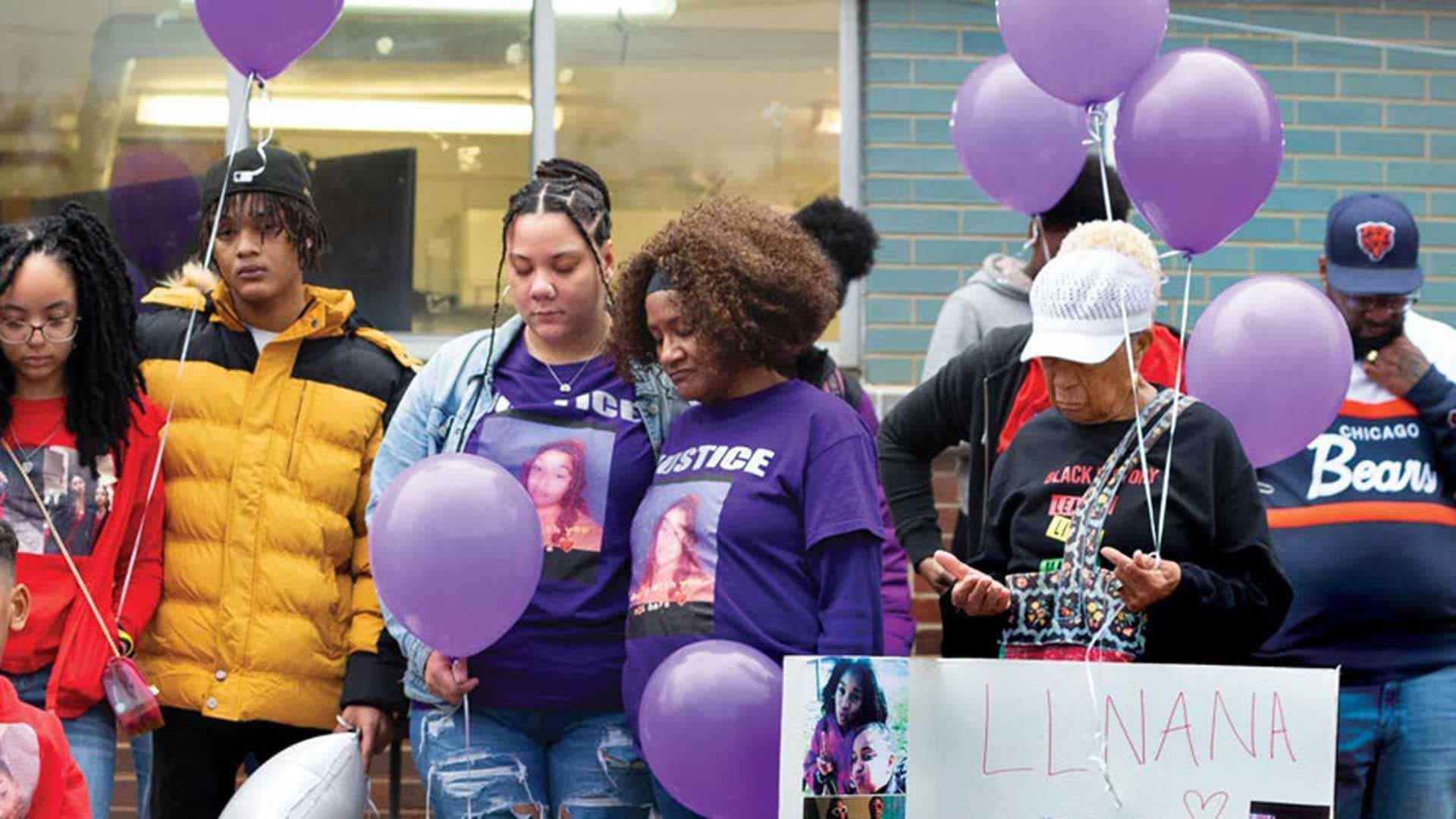 mourners gather with purple balloons