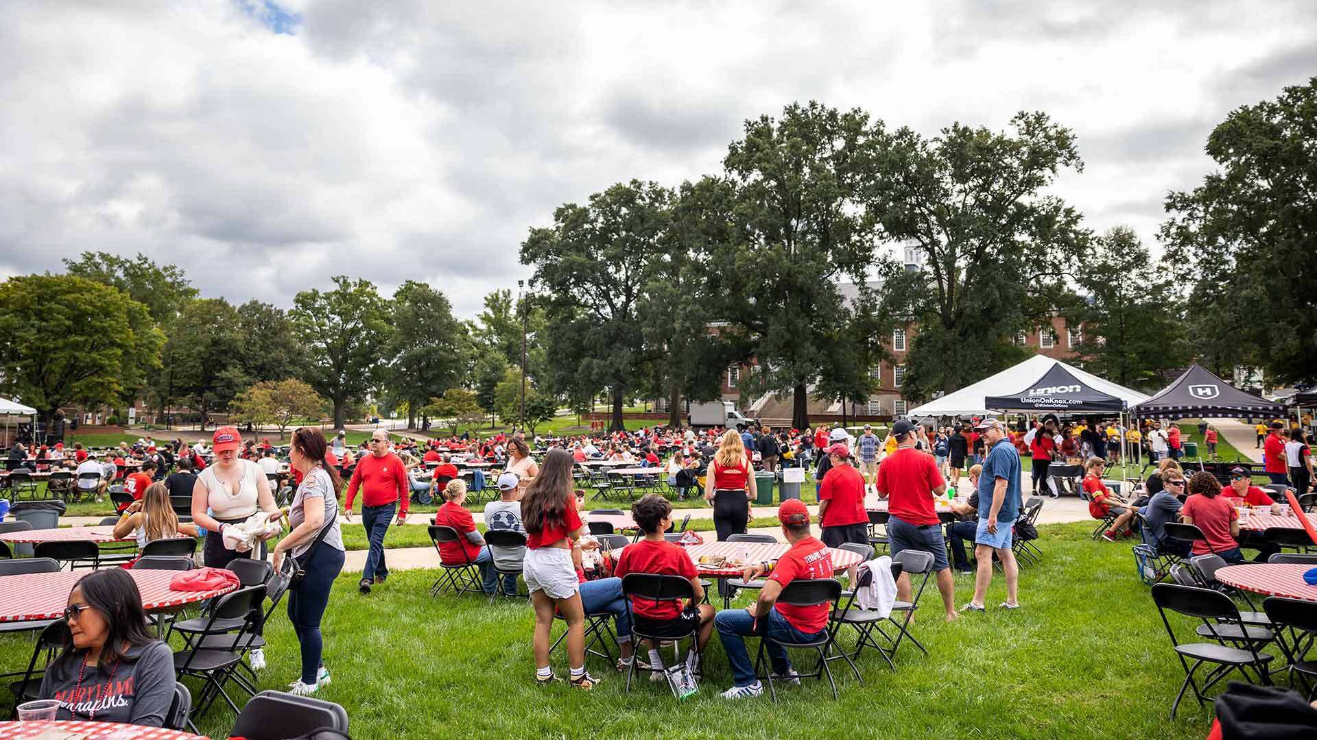 hundreds of people eat at tables set up on mckeldin mall under a cloudy sky