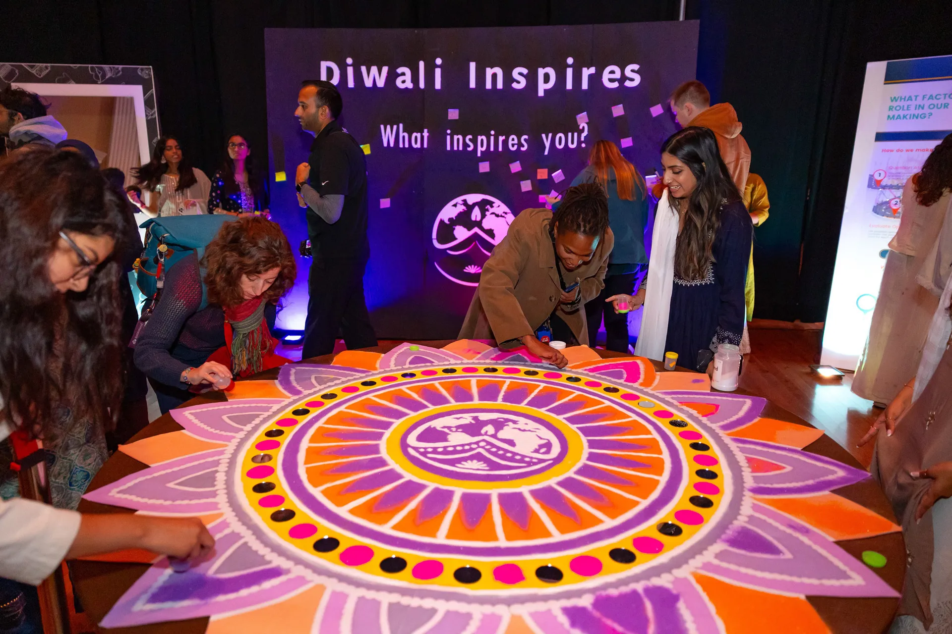 students around a floral design in purple, orange and red