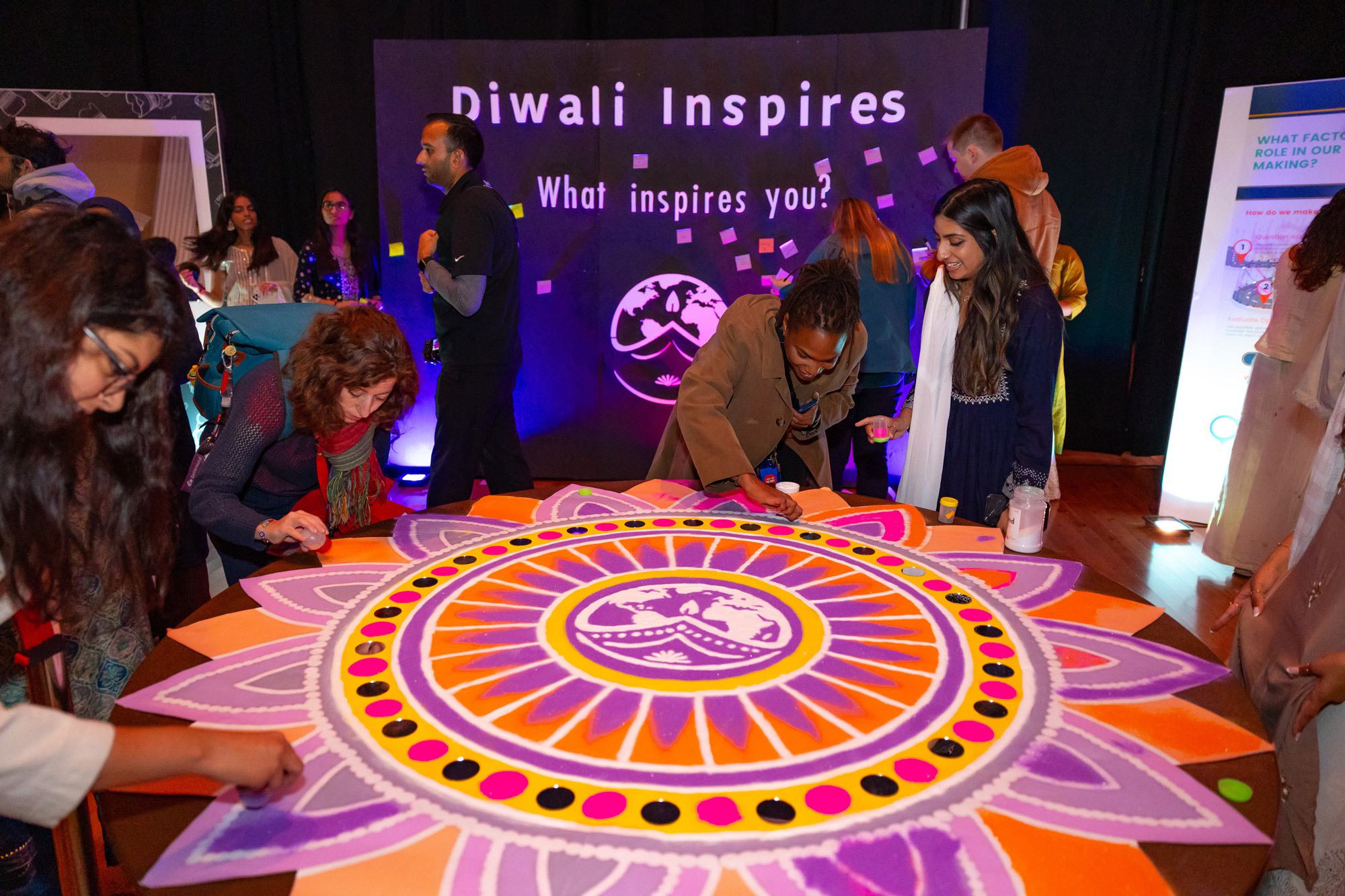 students around a floral design in purple, orange and red
