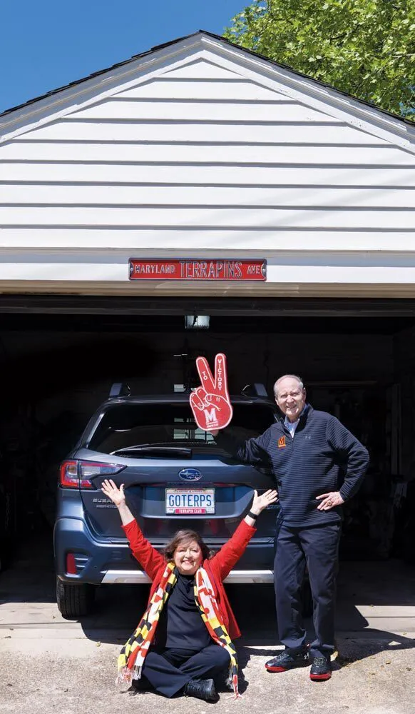 couple poses by car with "GOTERPS" license plate in garage