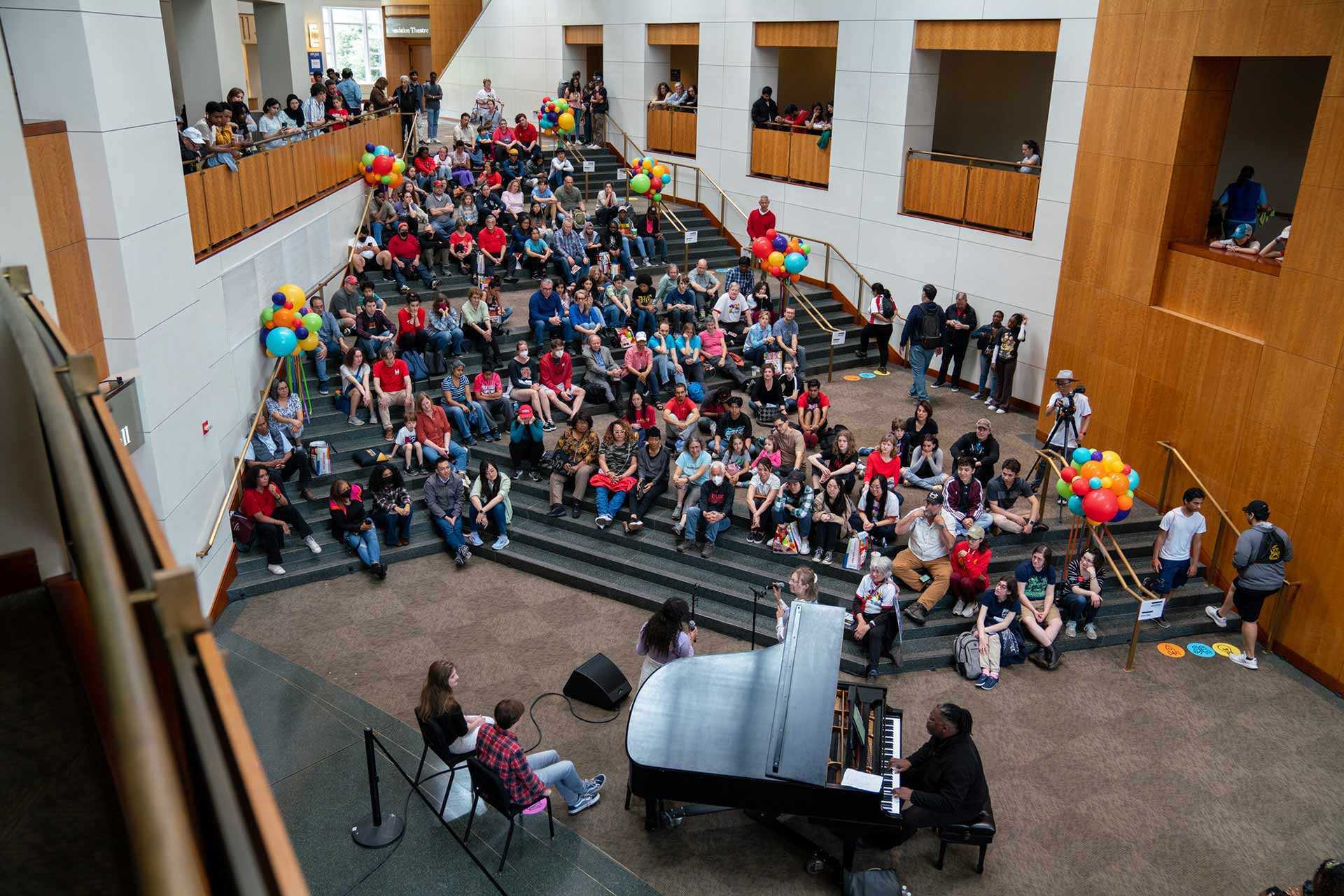 audience gathers around piano