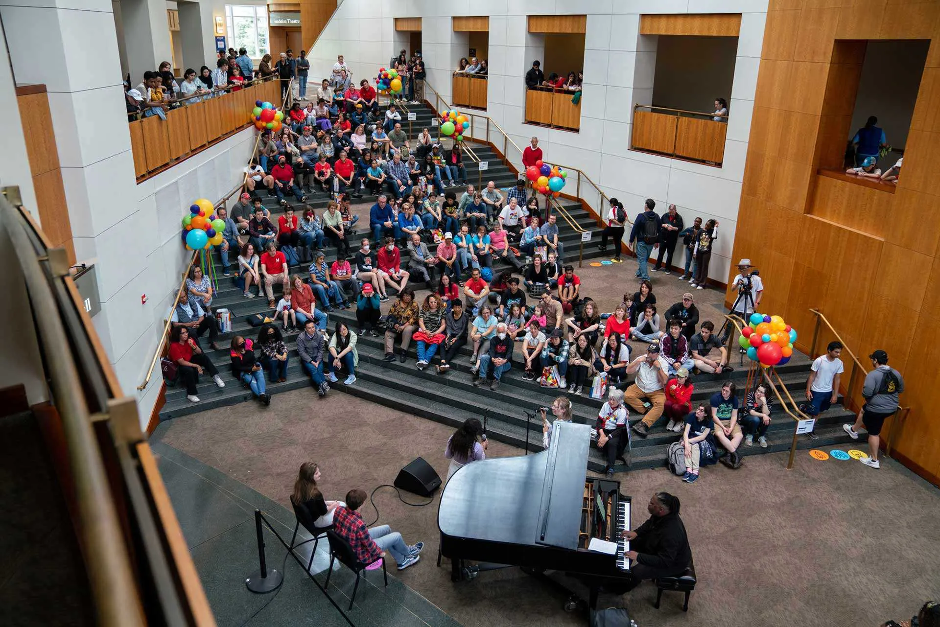 audience gathers around piano