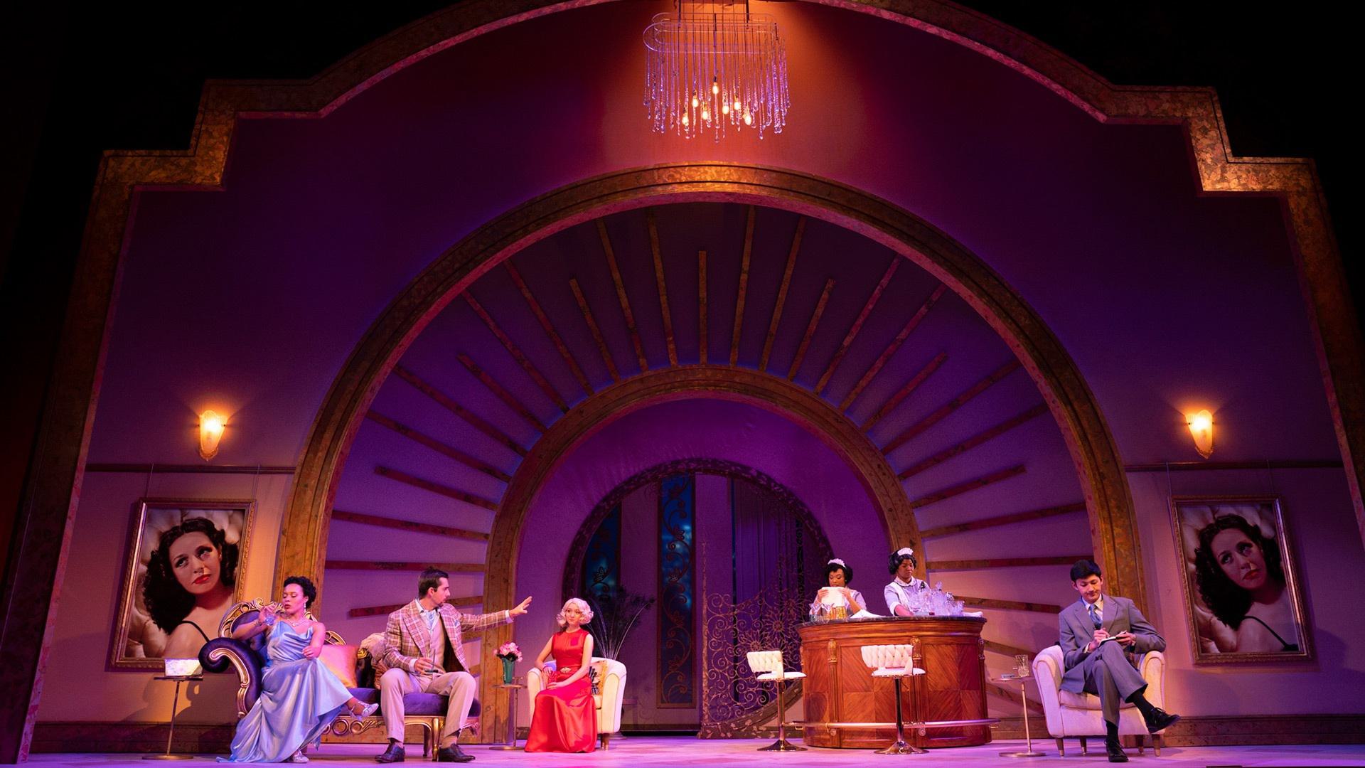 Actors on a purple lit stage