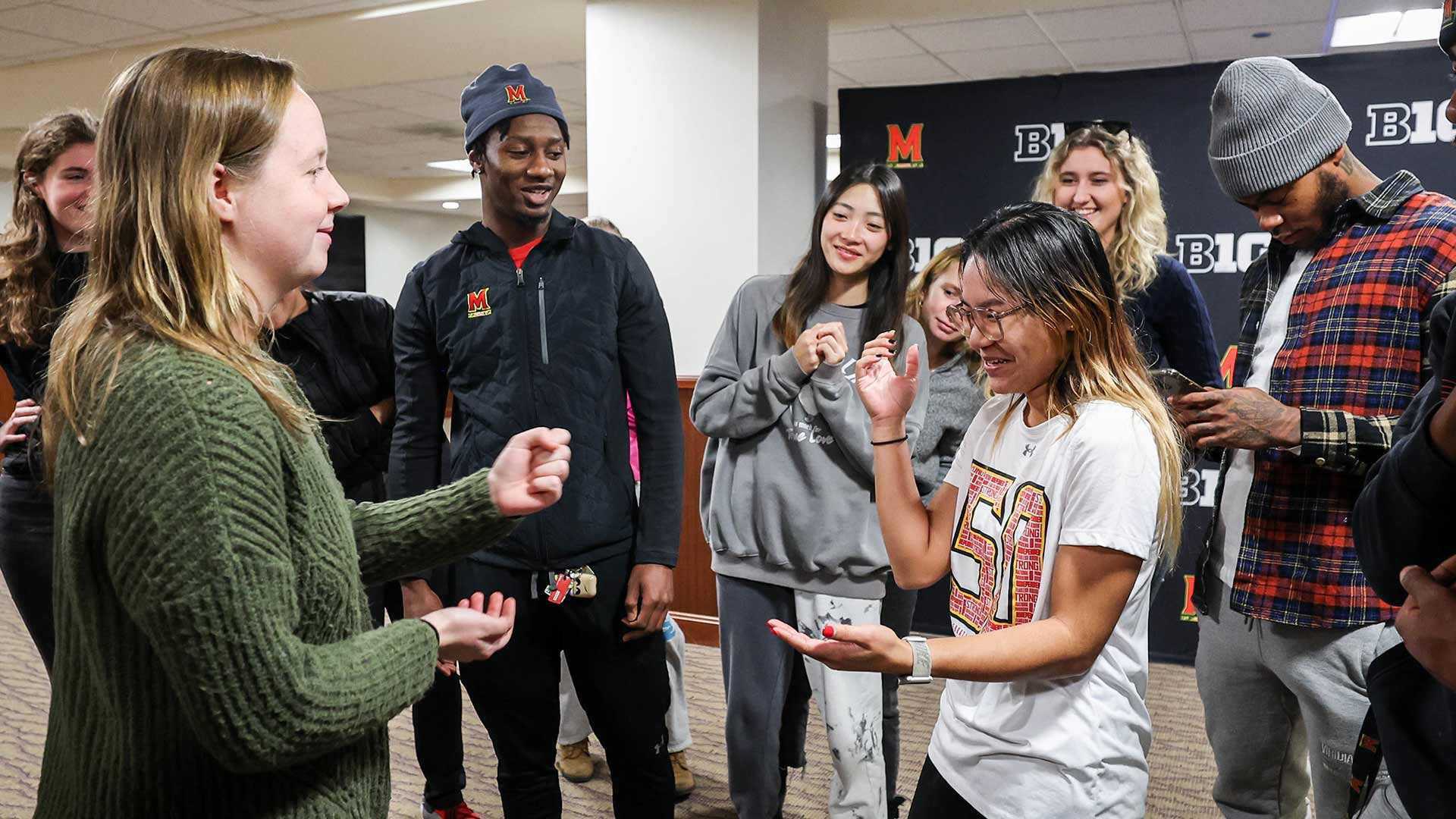 Students playing games with their hands while standing