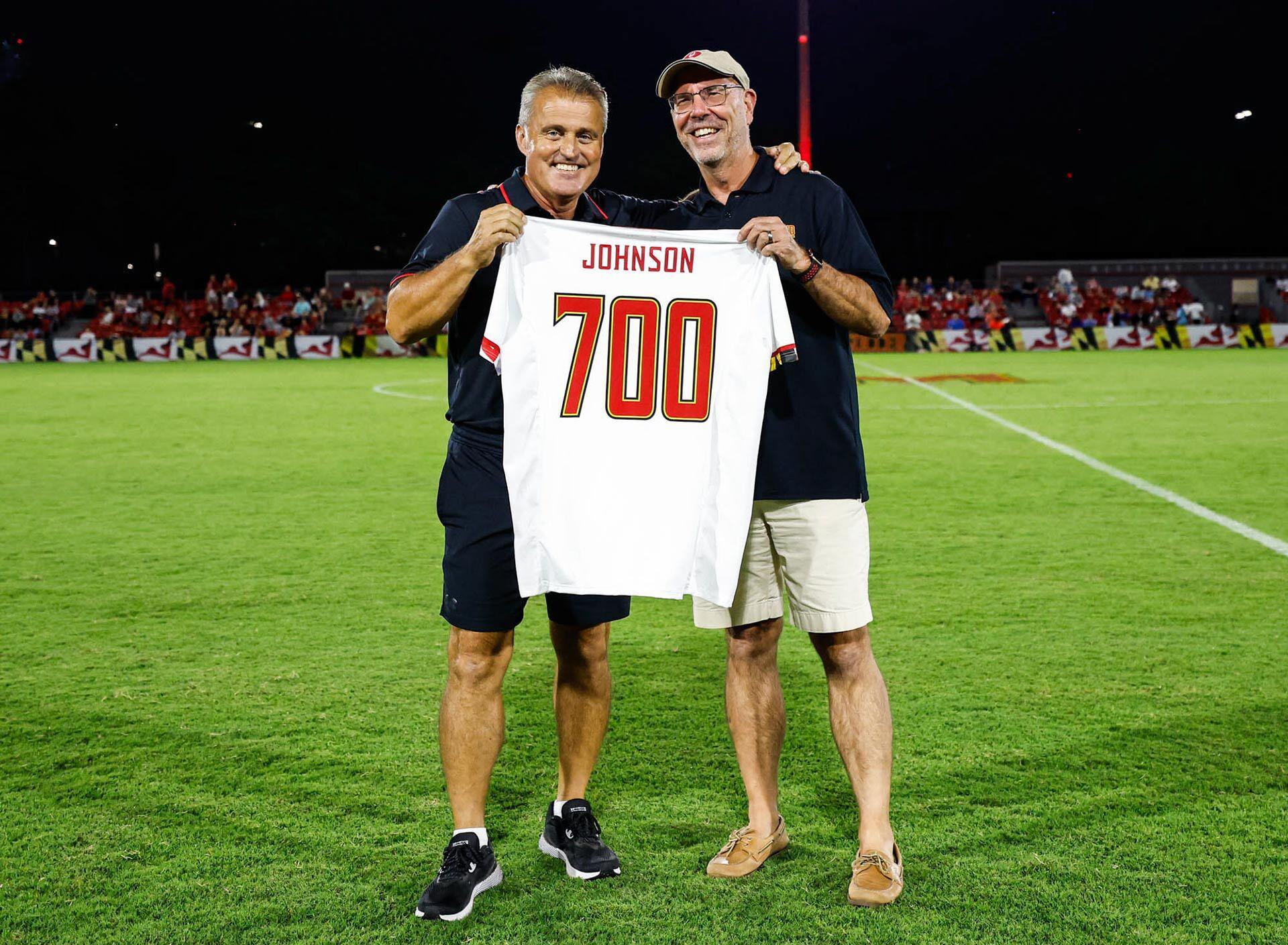 Sasho Cirovski and Bob Johnson pose with a "700" Johnson jersey
