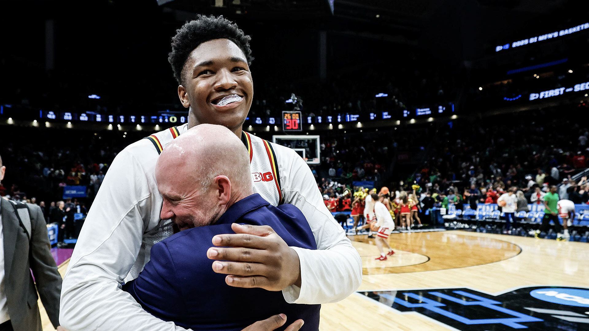Derik Queen hugs coach Kevin Willard