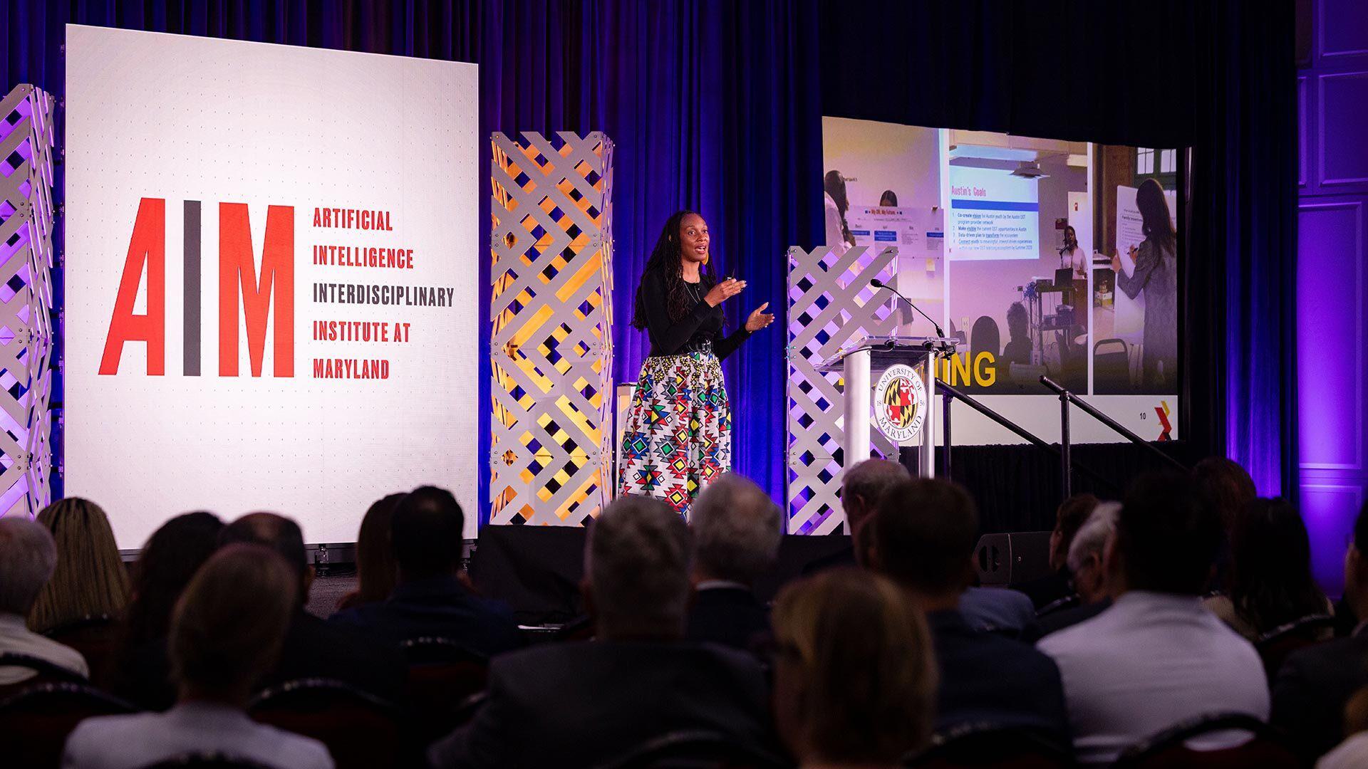 Sheena Arete presents on stage at AIM event