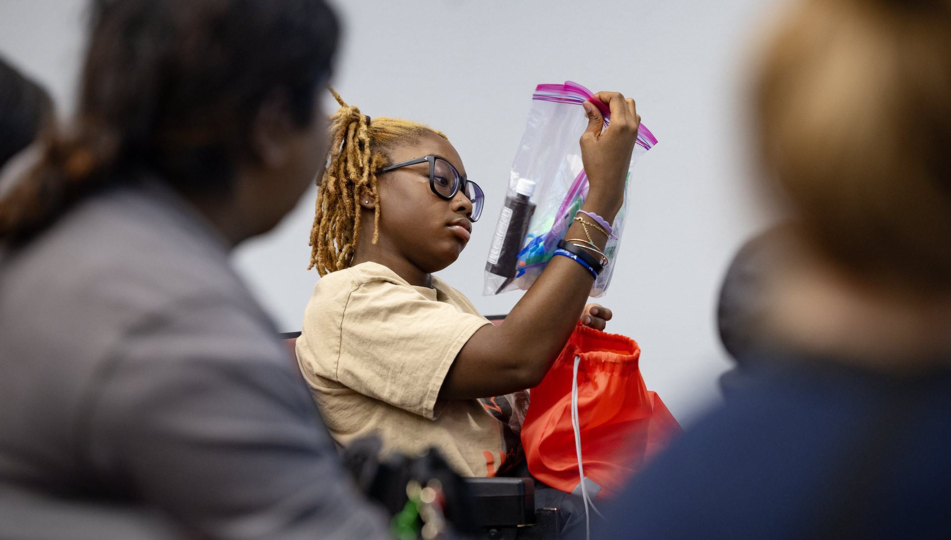 student looks over bag of items for show dog care
