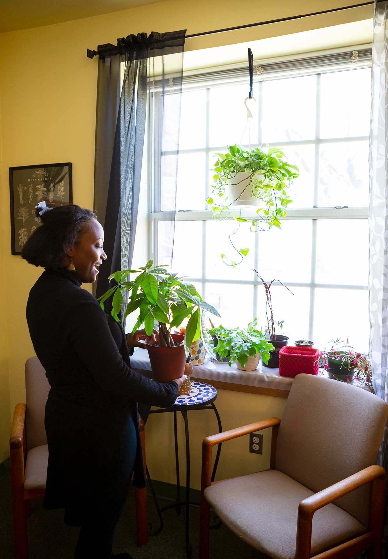 Aaliyah Flores holds plant near window