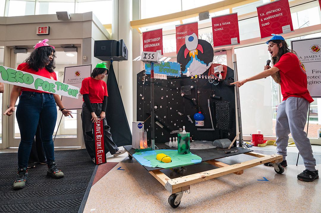 a student excitedly shouts an explanation of a strange machine