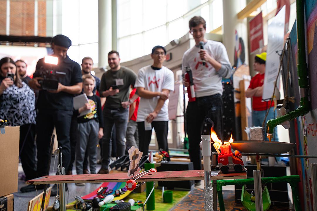 Several team members help explain a complicated machine