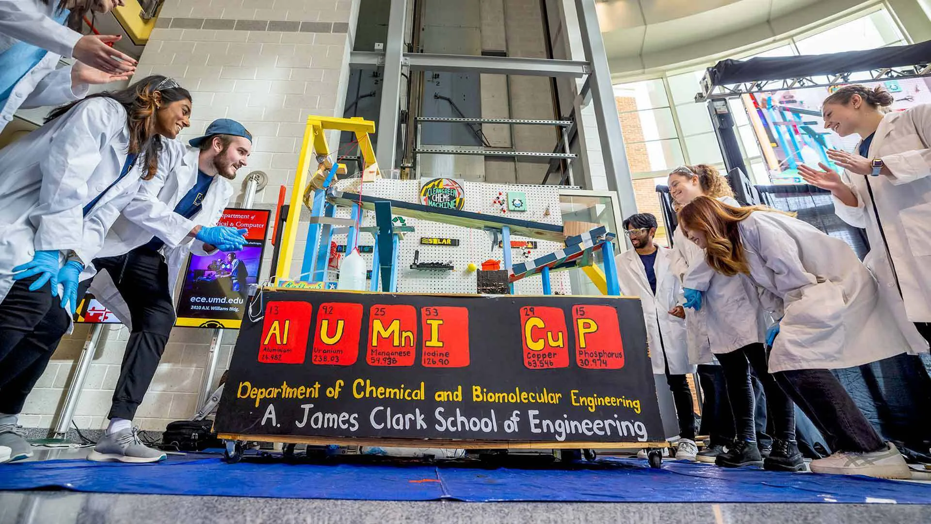 students gather around a rube goldberg machine