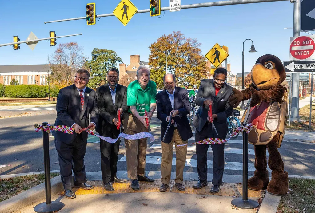 people and mascot cut a ribbon on a street