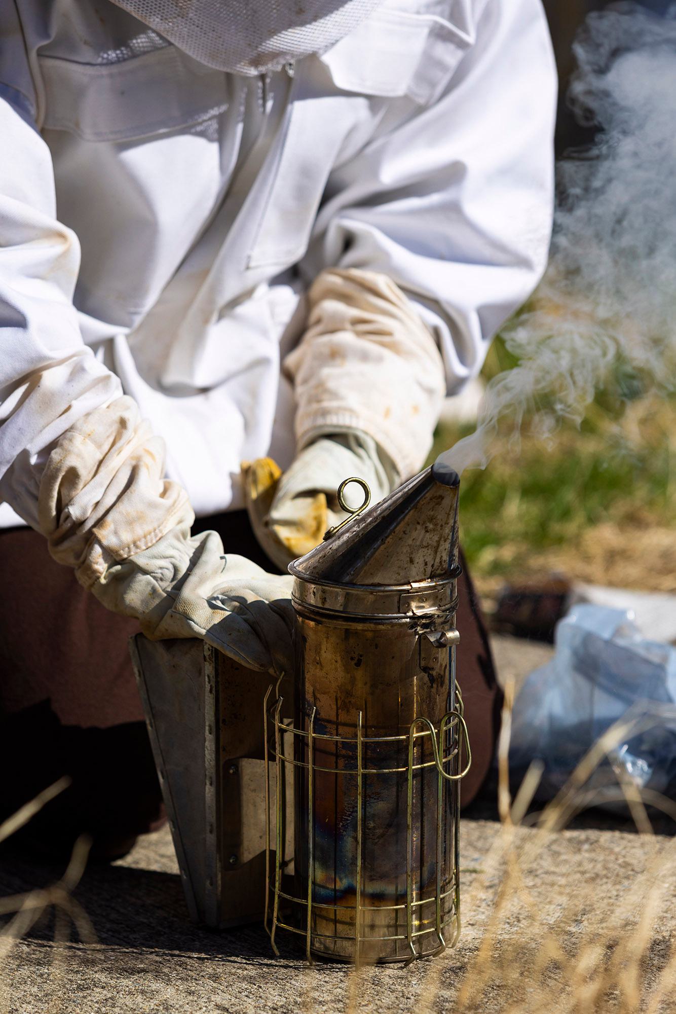 White gloved hands hold a small smoker