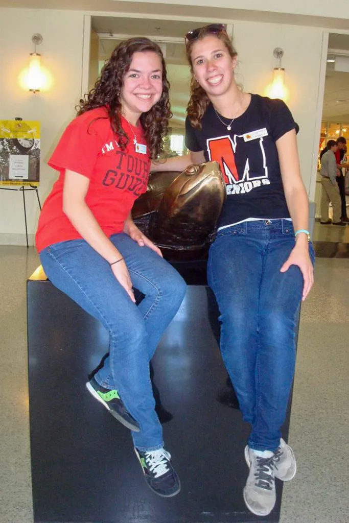 Corie Sunder and Lisa Berglund sit by the statue of Testudo