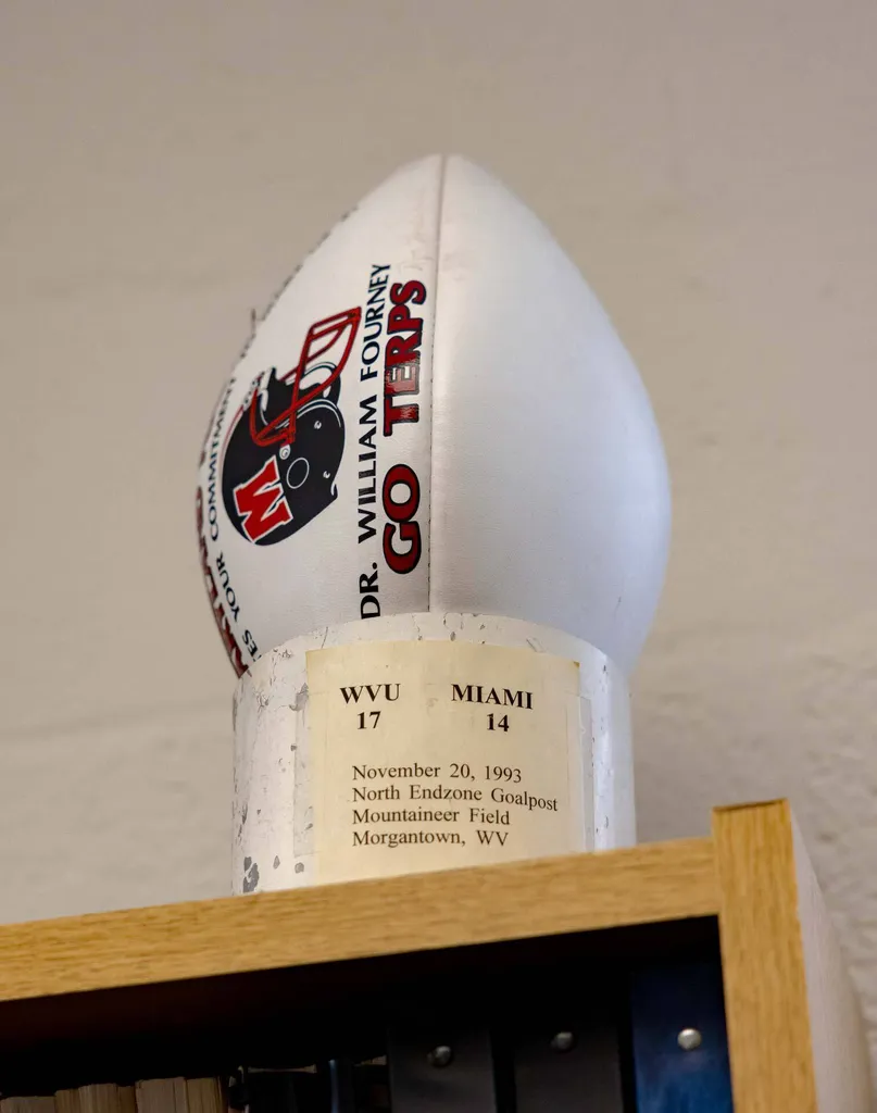 football with Go Terps and Dr. Bill Fourney written on it sitting in a piece of white goal post