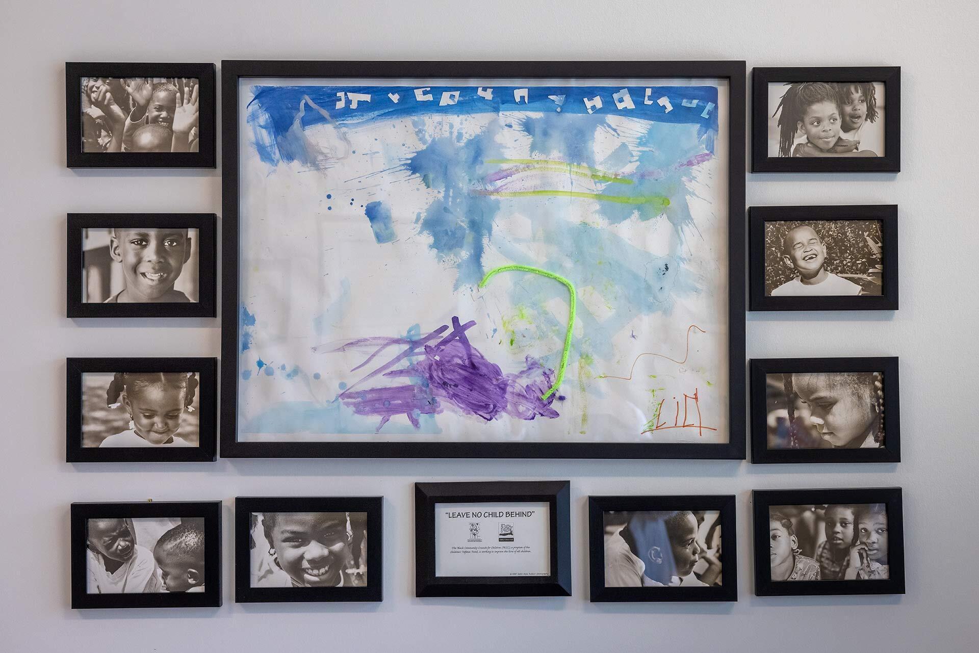 Black and white photos of black children surround a colorful child's drawing