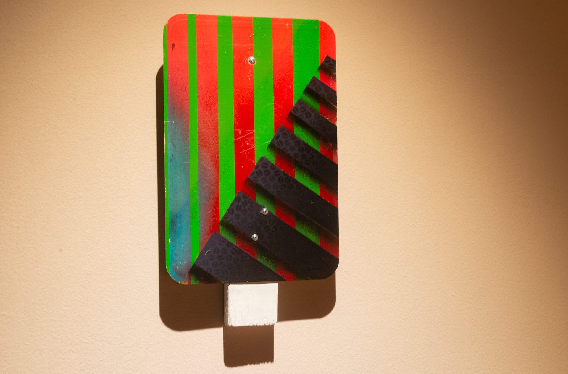 red, green and black striped “Street Sign” artwork
