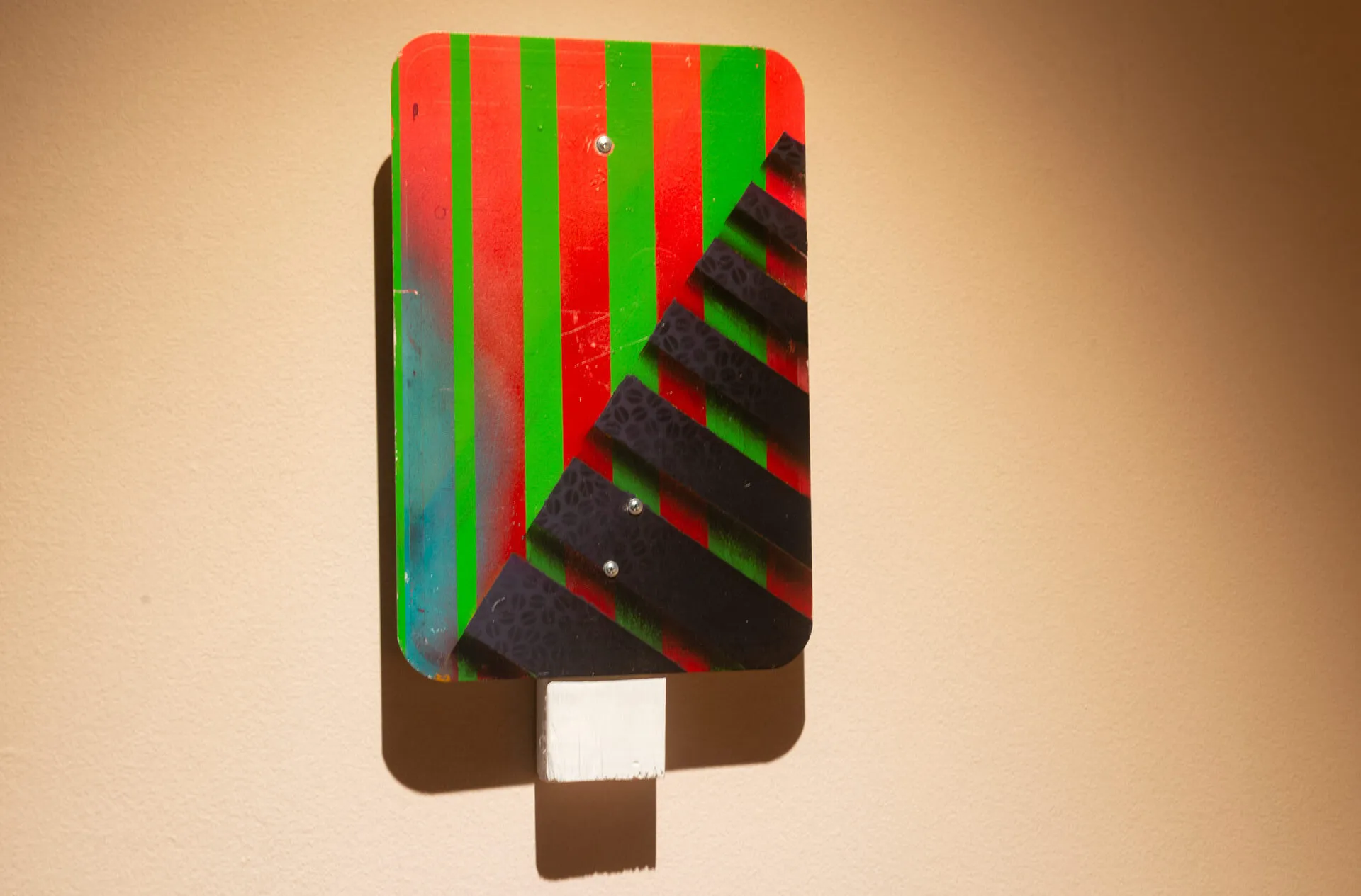 red, green and black striped “Street Sign” artwork