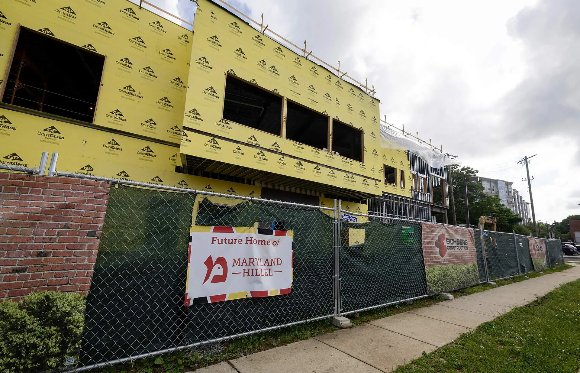 building with yellow construction paper and sign on fence reading, "Future home of Maryland Hillel"