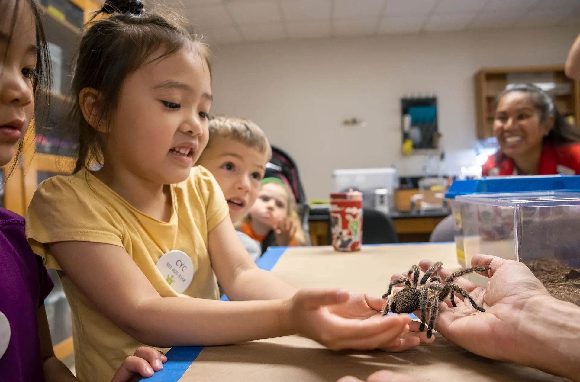 young student holds tarantula