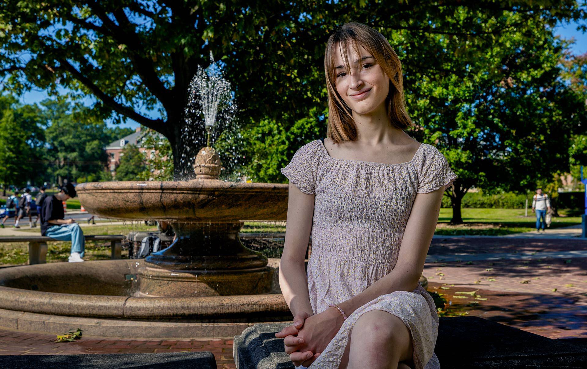 Hannah Cairo sits by a fountain