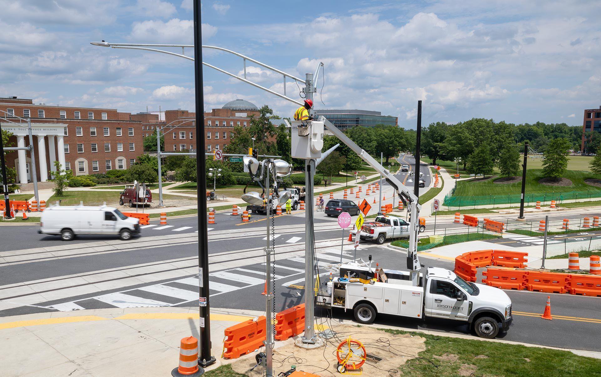construction workers work on new traffic light at intersection