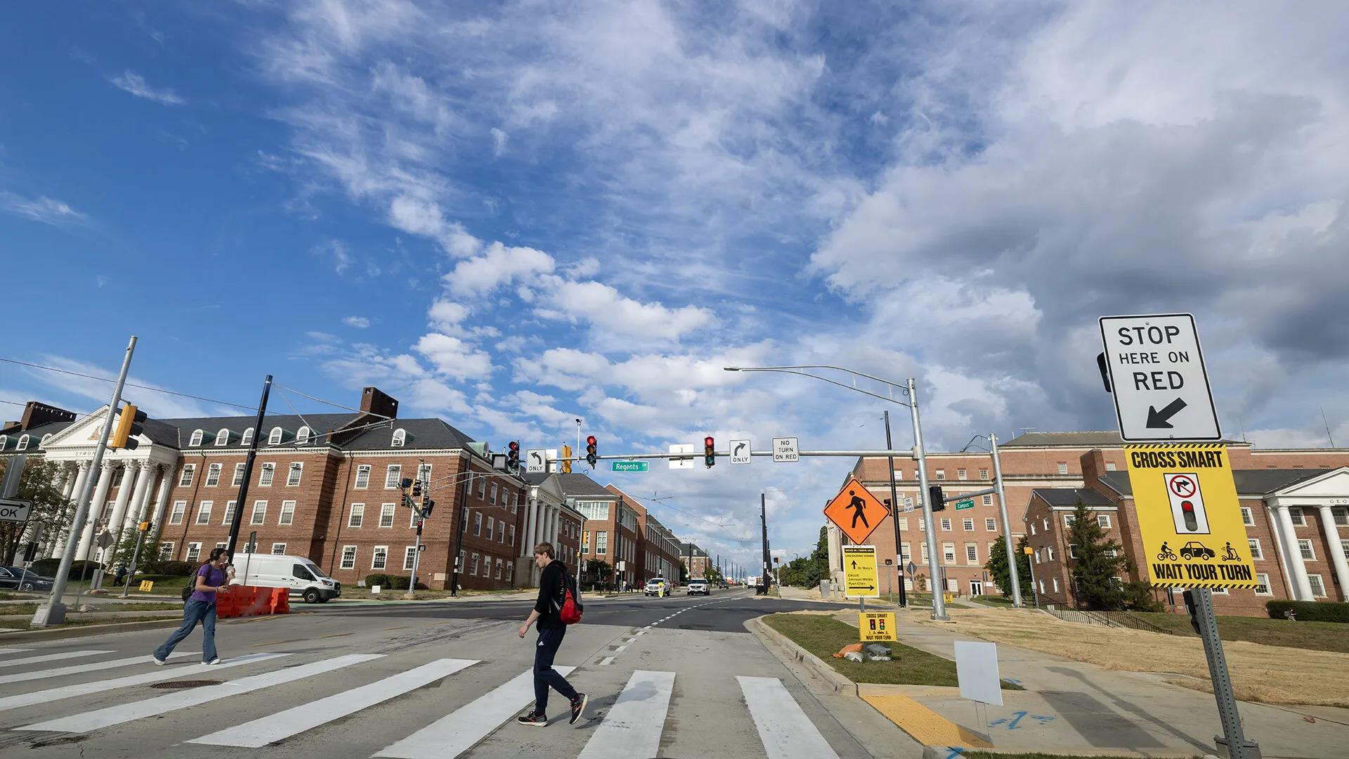 students cross street at crosswalk at new stoplight at Regents Drive
