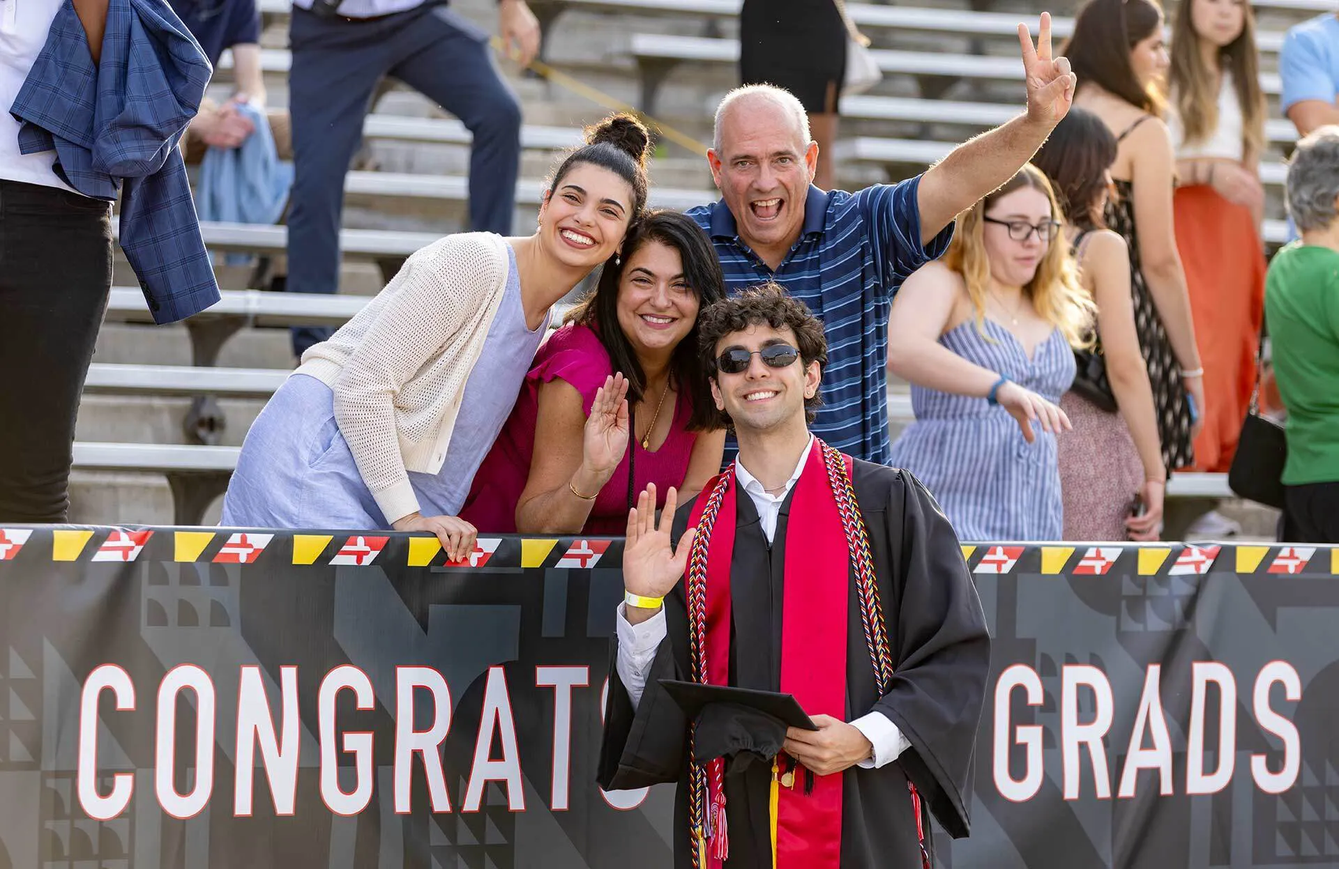 graduate poses with three family members