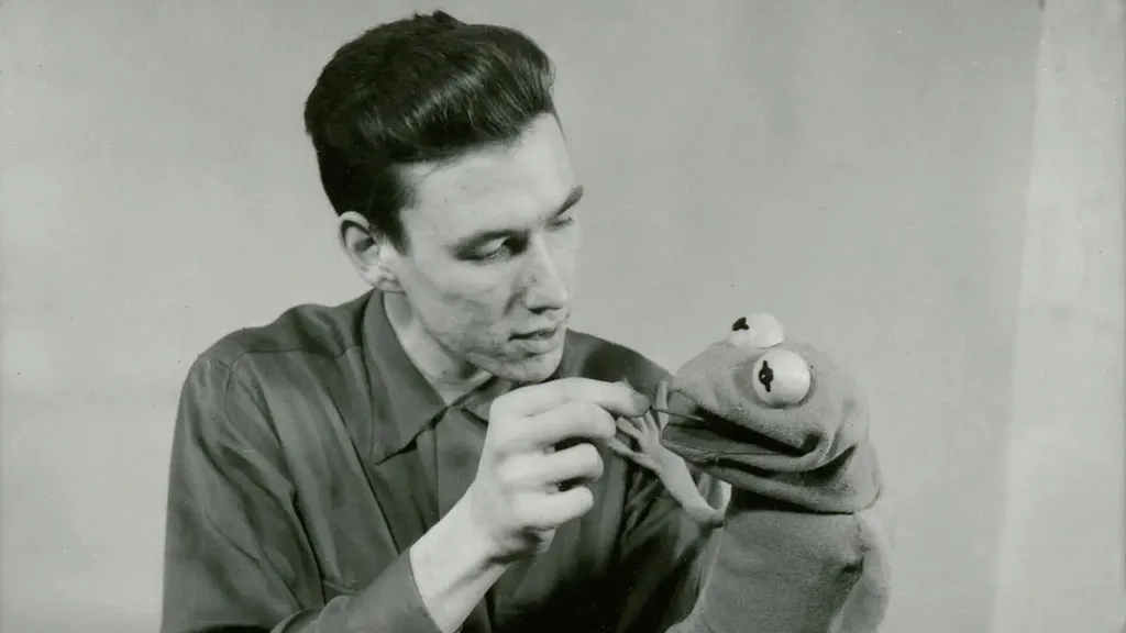 Black and white photo of a young Jim Henson with the first iteration of Kermit the Frog