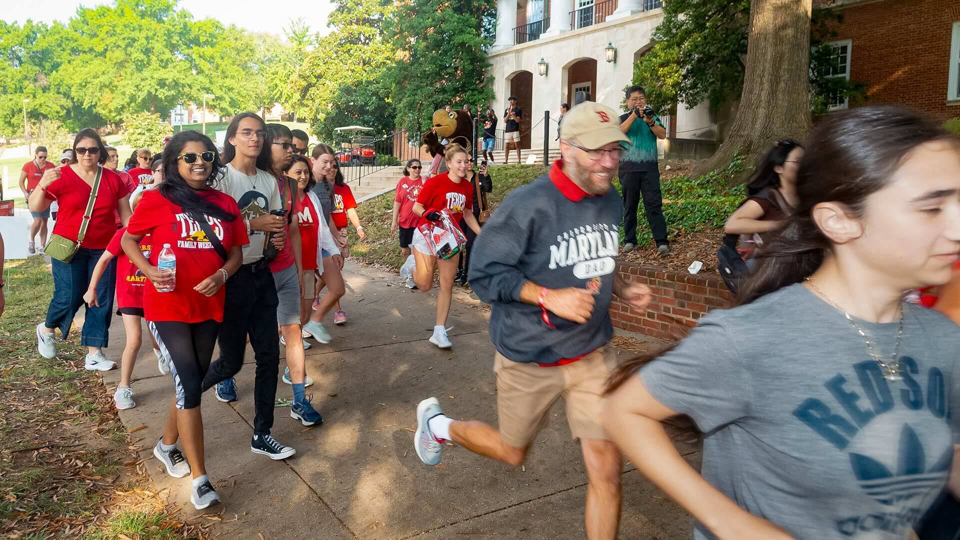 a group of people run past, some not wearing traditional running costumes