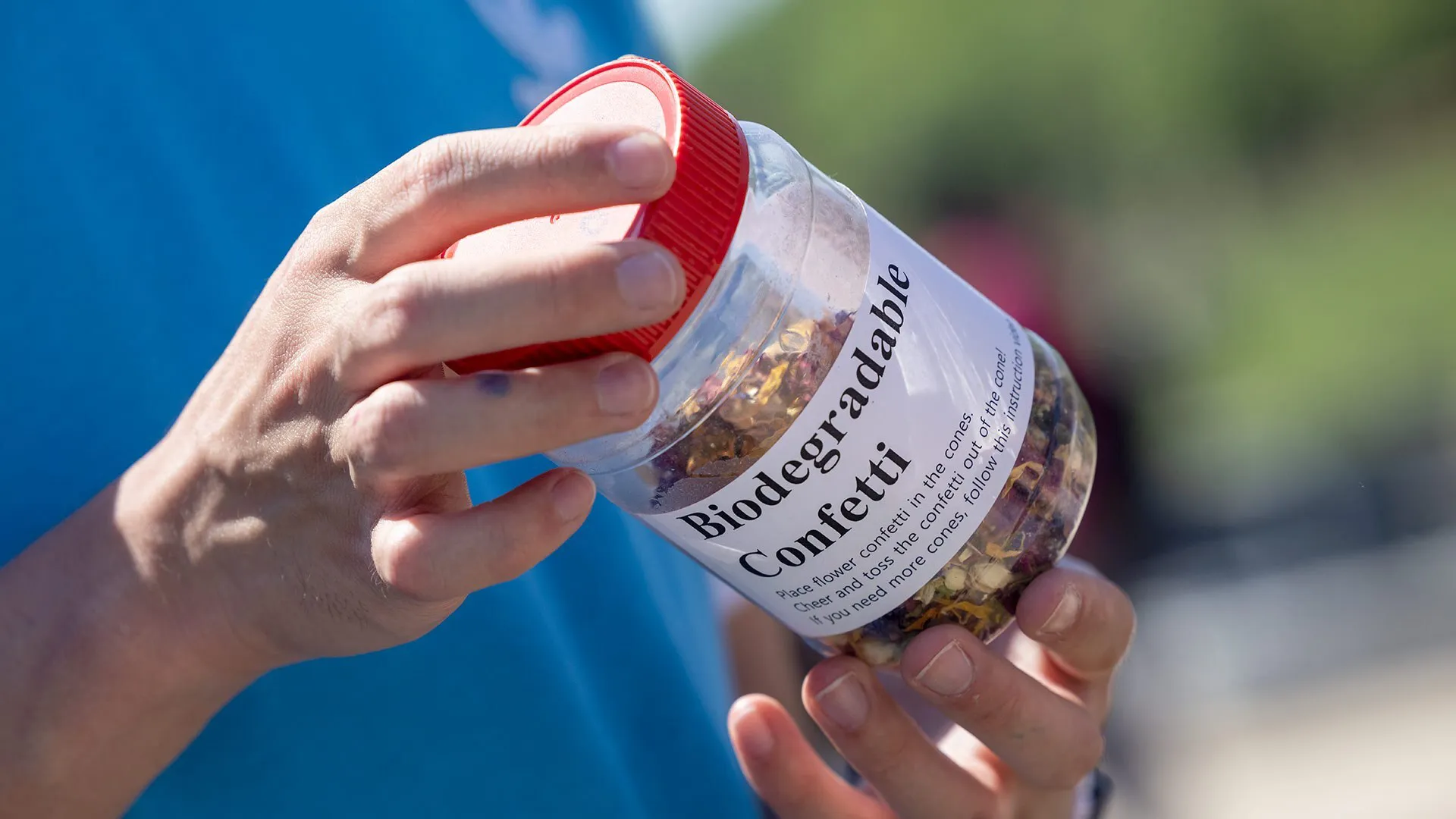 hands holding container of biodegradable confetti