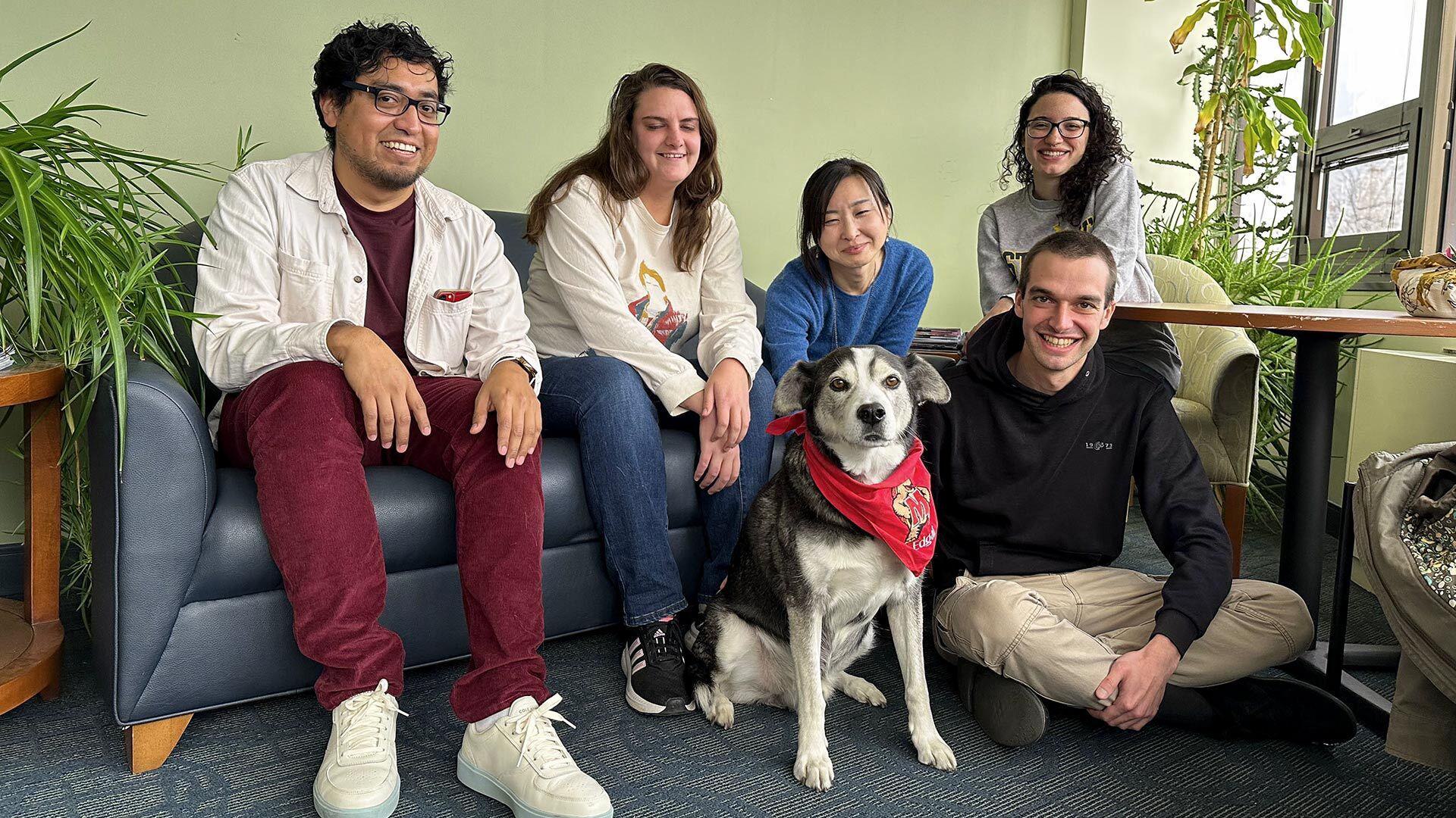 dog with red bandana sits with group of five people