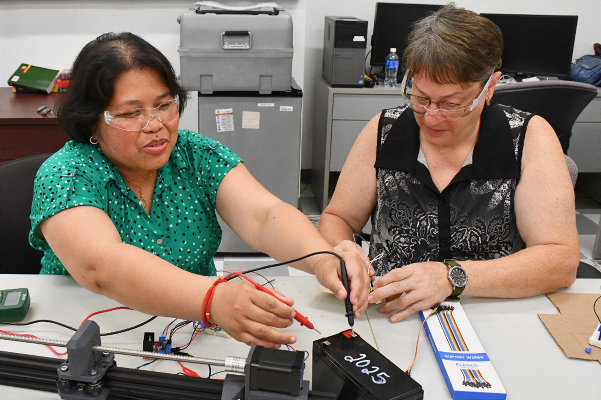 Two teachers work on a technology project