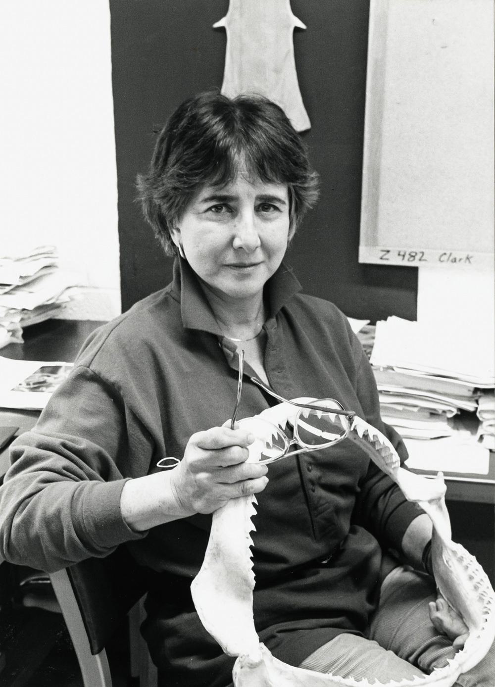 Black and white photo of Eugenie Clark holding a shark jaw bone