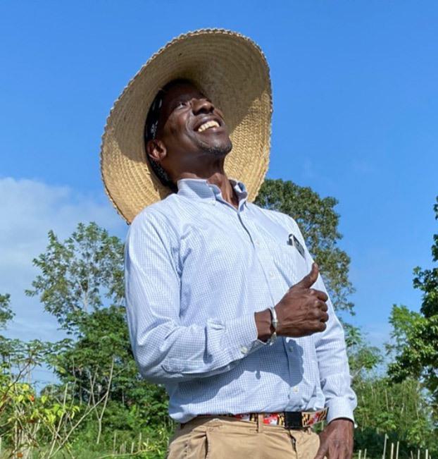 a man in a wide-brimmed straw hat and a blue button-down shirt