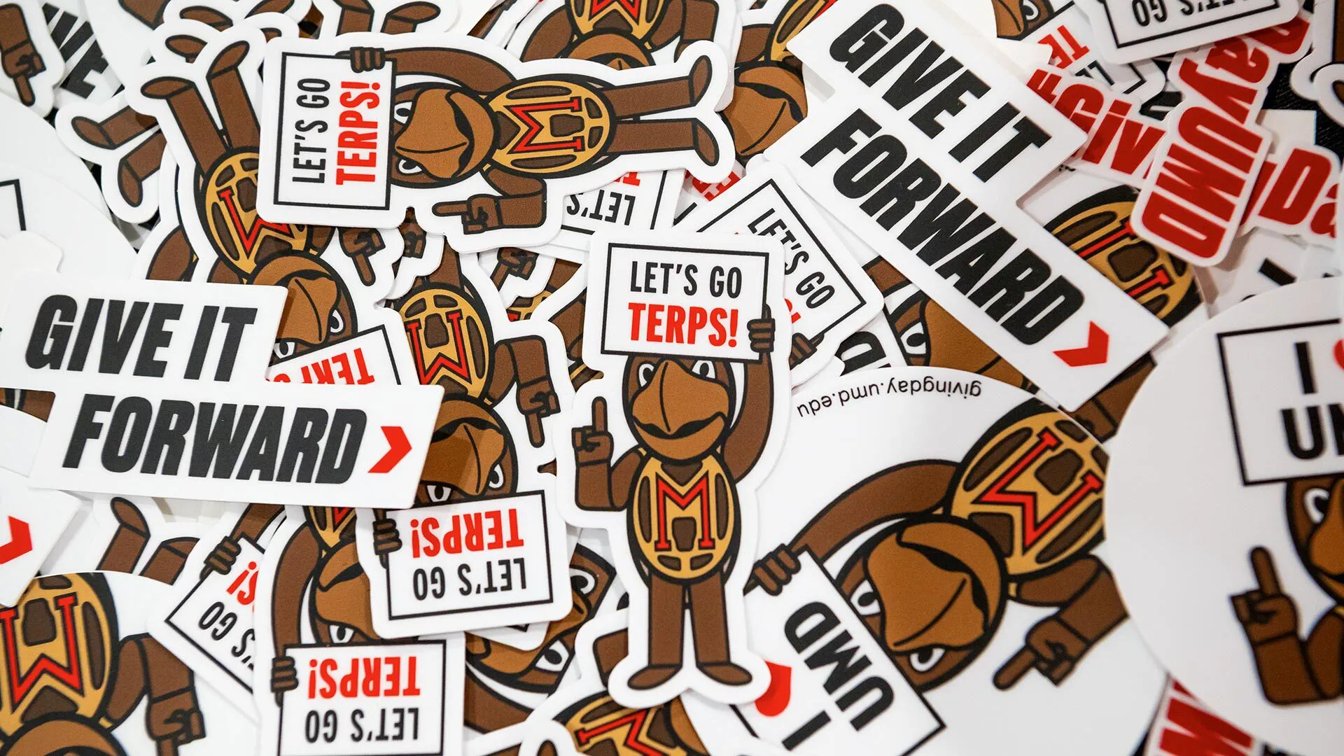pile of Testudo stickers that say, "Give it Forward" and "Let's go Terps!"