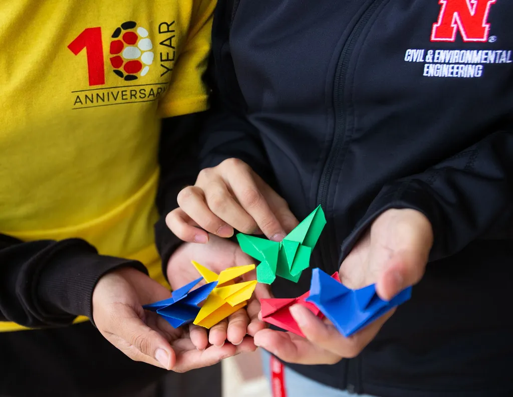 Volunteer demonstrating how to create origami bookmarks